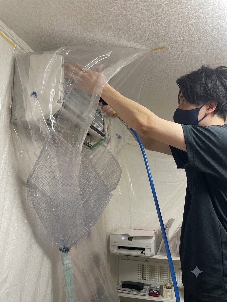 養生をしたエアコンを高圧洗浄している作業の様子